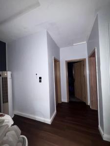 an empty room with white walls and wooden floors at Alexa Smart Home One Bedroom Luxury Apartment in Lekki