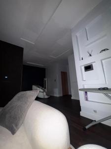 a bedroom with a white bed and a white desk at Alexa Smart Home One Bedroom Luxury Apartment in Lekki
