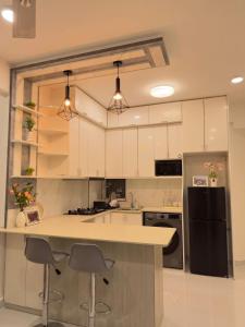 a kitchen with white cabinets and a black refrigerator at Bougainvillea Breeze in Male City