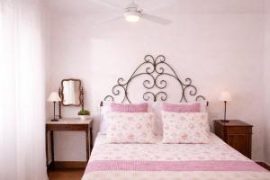 a bedroom with a large bed with pink pillows at La Vignaredda - Residenza di Charme in Aggius