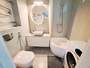 a bathroom with a sink and a toilet and a mirror at Cozy Vintage Apartment in Klaipėda