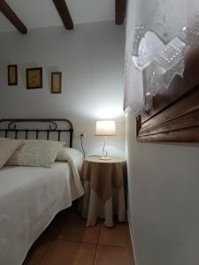 a bedroom with a bed and a lamp on a table at La Simona Casa Rural in Perales del Puerto +50 photos