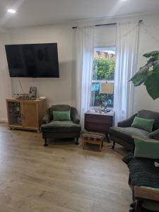 a living room with two chairs and a flat screen tv at Casa Dorado - Bright, Sunny 2 Bedroom 1 Bath House - Fenced Yard, Private Patio in Santa Barbara