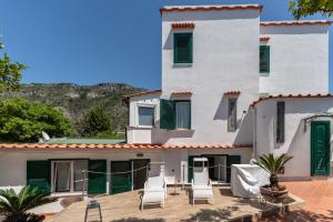 a house with chairs on a patio at Villa Anna in Meta