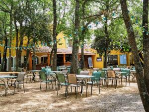 a group of tables and chairs in front of a building at Domaine Les Chênes Blancs in Saint-Saturnin-lès-Apt
