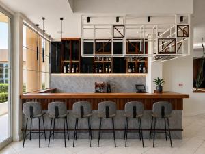 a bar in a room with stools around it at Eleftheria Hotel in Agia Marina Nea Kydonias