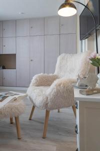 a white furry chair sitting in a room at Hein Wichtig in Boostedt