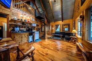 a living room with wooden walls and a wooden floor at Riverview Cabin in Helen +6 photos