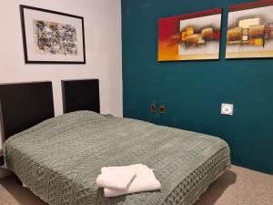 a bedroom with a bed and a blue wall at Casa del Horno in El Cinco de Mayo