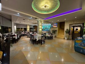 a dining room with tables and chairs in a restaurant at Hotel Driloni in Ksamil