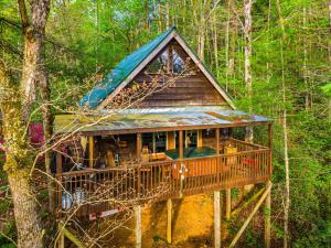a tree house with a deck in the woods at Riverview Cabin in Helen