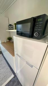 a microwave sitting on top of a refrigerator at Premium Stuga, Near Göta Canal & Tiveden National Park in Undenäs +65 photos
