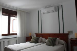 a bedroom with two beds and two windows at La Posada del Conde in Ardales