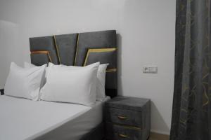 a bed with a black headboard and white pillows at Studio MLK in Chefchaouen +11 photos