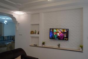 a tv on a white brick wall in a living room at Studio MLK in Chefchaouen