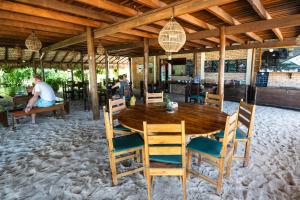 a wooden table and chairs in a restaurant at Pousada Casa Suiça in Itarema