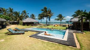a woman laying in a swimming pool at a resort at Pousada Casa Suiça in Itarema
