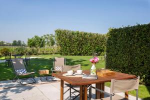a wooden table with a vase of flowers on a patio at Massoni Wine Relais in Peschiera del Garda