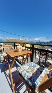 Ein Tisch und Stühle auf einem Balkon mit Blick auf das Meer in der Unterkunft Pelekas loft in Pelekas + 13 Fotos