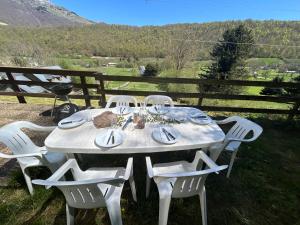 a white table and chairs with a view of a field at Chalet de montagnes in Campan