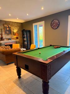 a living room with a pool table and a clock at Hotel Clair de Lune in Zonza