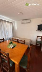 a dining room with a table and a bed at Cabañas Portofino todo incluido in Ramallo