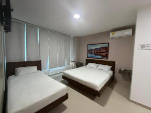 a room with two beds in a room withermottermott at Hotel Suites Caribe in Barranquilla +51 photos