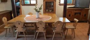 a wooden dining room table with chairs and a vase on it at Czereśniowy Dom dom na imprezy kawalerskie bunkry warsztaty in Goruńsko +4 photos