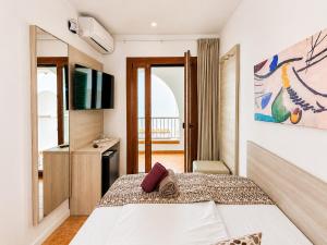 a hotel room with a bed and a television at Hotel Ses Puntetes in Cala d´Or