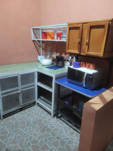 a kitchen with a counter with a microwave on it at Hostal viroleño in Zacatecoluca
