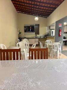 a dining room with a table and white chairs at Pousada Morada Nobre in Barreirinhas