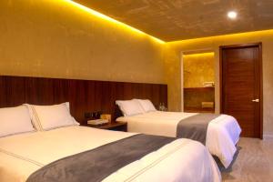 a hotel room with two beds and a window at 7 Casa Laurel Hotel Boutique in Oaxaca City +29 photos