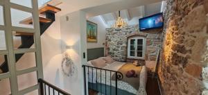 a bedroom in a stone house with a tv on the wall at Sundial Stone House in Ždrelac