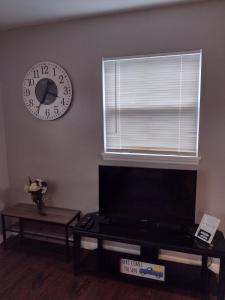 a living room with a clock on the wall and a table at Whole House All Yours! in Cocoa