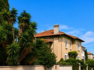 a large house with palm trees in front of it at Chambre dans villa privée, charme et confort proche Vélodrome & plages - Parking privé in Marseille