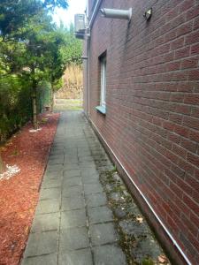 a brick wall with a sidewalk next to a building at Studio confortable situé à Woluwe Saint Lambert in Brussels