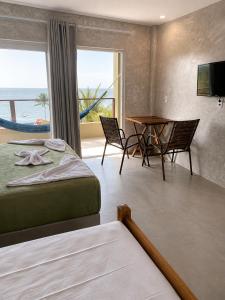 a hotel room with a bed and a table and a window at Casas de Juan in Morro de São Paulo