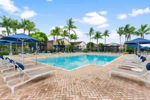 a pool with lounge chairs and umbrellas at a resort at Kasa Wellington South Florida in Wellington +51 photos