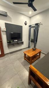 a living room with a table and a flat screen tv at KRS PARADISE premium suite room in Tiruvannāmalai