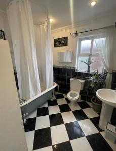 a bathroom with a black and white checkered floor at Wild Atlantic View in Walshestown