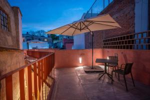 a table and an umbrella on a balcony at Hotel Casa de las Abuelas in Guanajuato