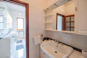 a white bathroom with a sink and a mirror at Aranci 99 House in Sorrento +18 photos