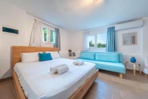 a bedroom with a large bed and a blue couch at Santa Decca in Áyioi Dhéka