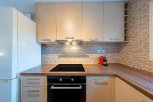 a kitchen with wooden cabinets and a stove top oven at Santa Decca in Áyioi Dhéka +12 photos