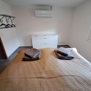 a bedroom with a large bed with two towels on it at Nest and Nature Strauch in Simmerath