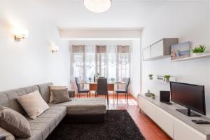 a living room with a couch and a tv at Refúgio do Mar -Steps from the Beach- in Armação de Pêra