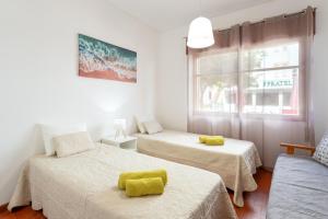 a room with two beds and a window at Refúgio do Mar -Steps from the Beach- in Armação de Pêra