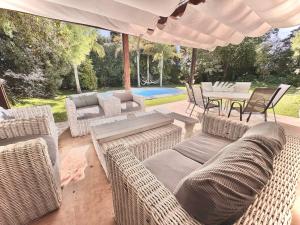 a patio with wicker furniture and a table and chairs at Mansión en Beverly Hills in Punta del Este