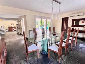 a dining room with a glass table and chairs at Mansión en Beverly Hills in Punta del Este