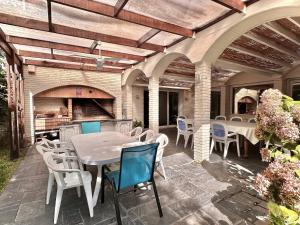 an outdoor patio with tables and chairs and an oven at Mansión en Beverly Hills in Punta del Este +33 photos